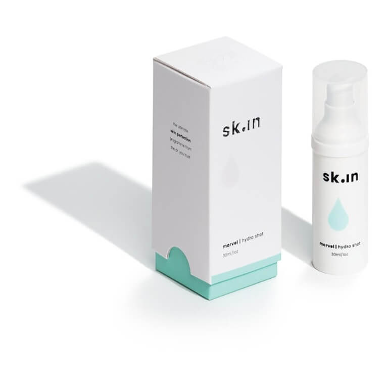 A bottle of sknn serum next to a box on a white background.