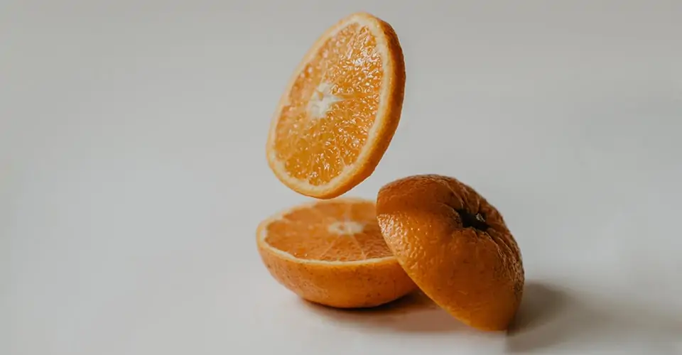 Two oranges, high in Vitamin C, on a white background.