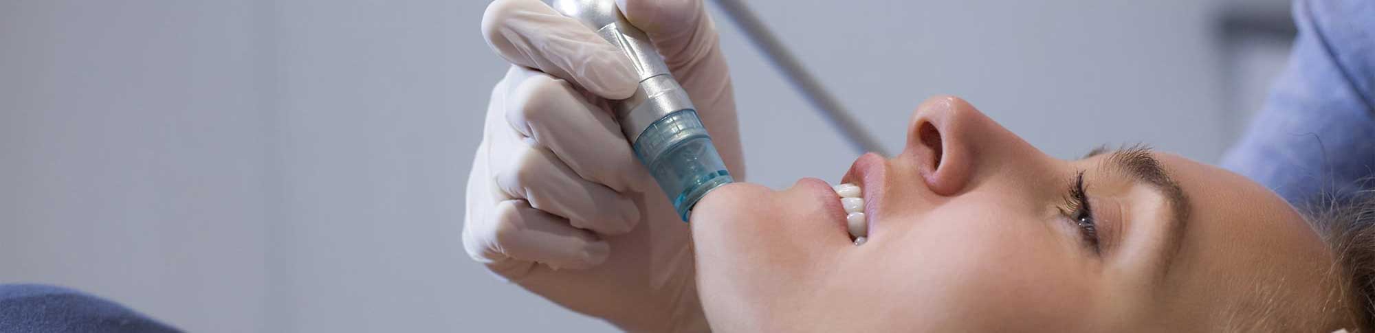 A woman is getting her teeth cleaned by a dentist.