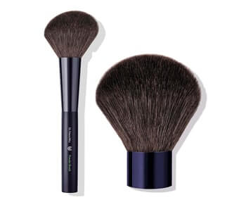 A makeup brush with a black handle on a white background by Dr. Hauschka.