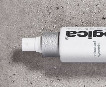 A Dermalogica bottle with a white label on it sitting on a concrete surface.