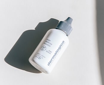 A Dermalogica bottle of spf 30 sunscreen on a white surface.