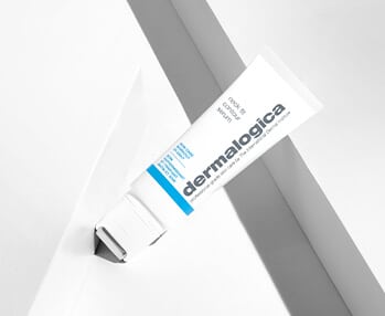 A tube of dermalogica anti-aging cream on a white wall.