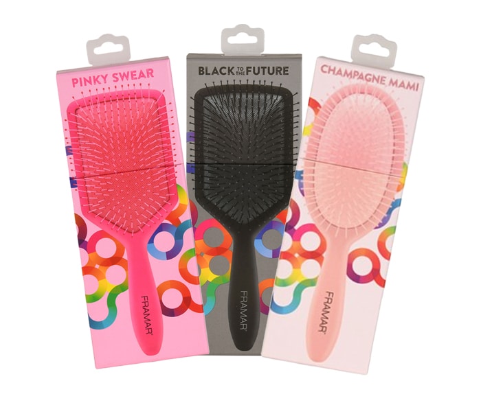Three pink and black hair brushes in packaging.